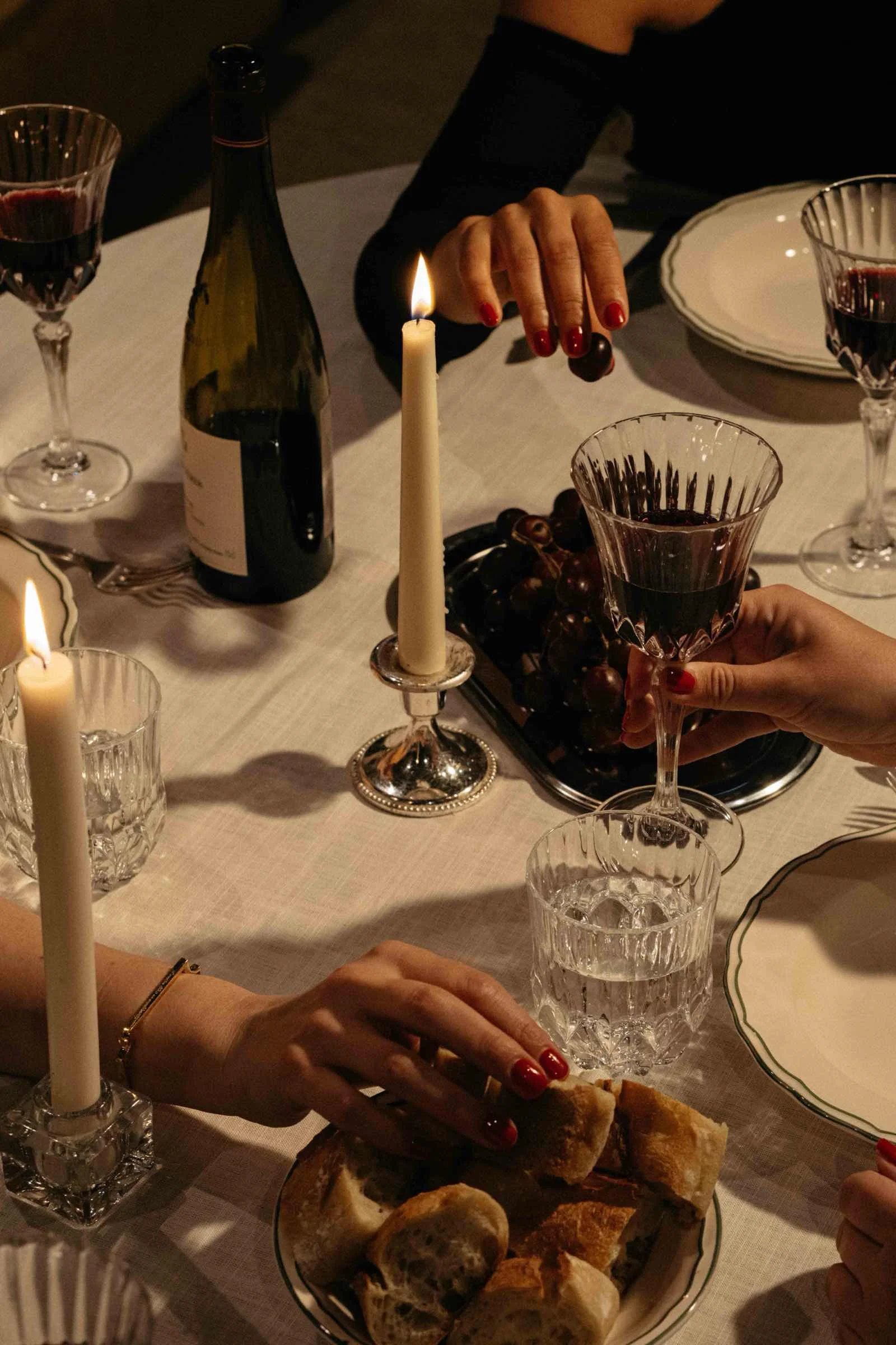 Guests in conversation over wine at a dinner table